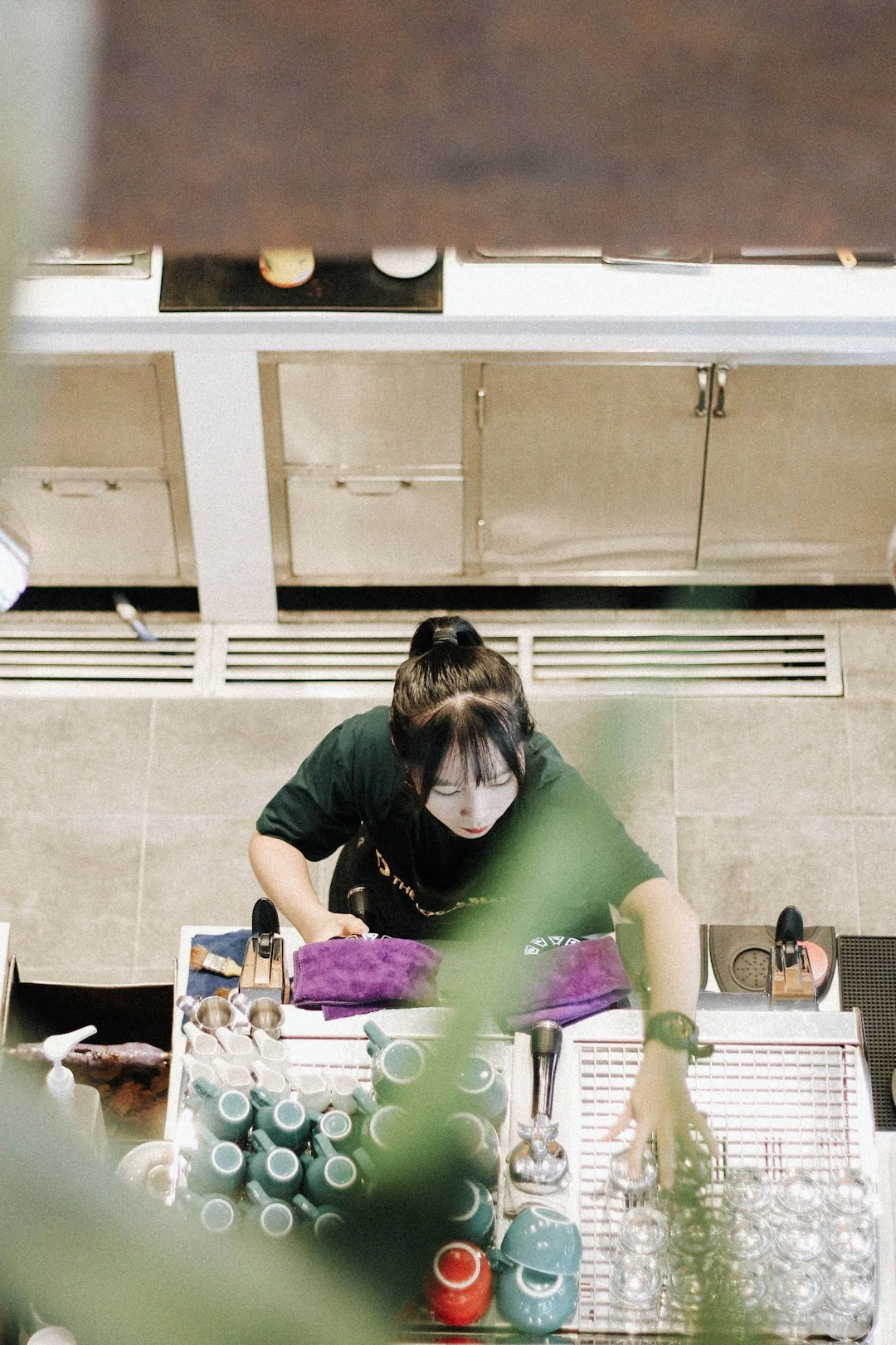 Two workers are suspended while cleaning windows on the facade of a modern skyscraper.